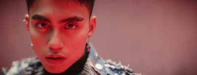 a man with red eyes wearing a jacket