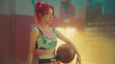 a woman with pink hair holding a basketball