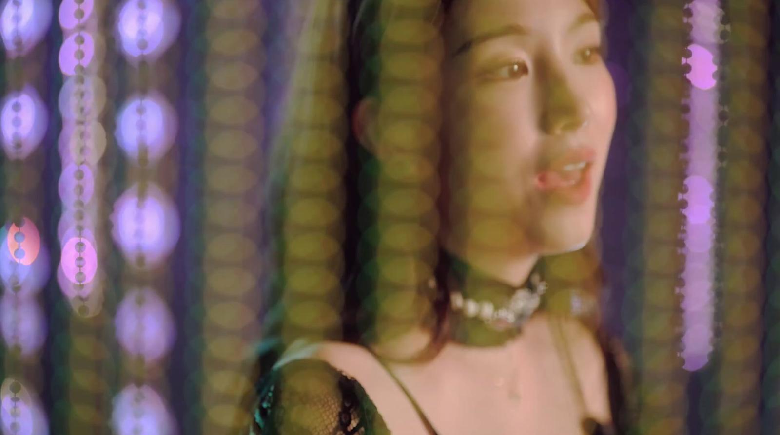 a woman in a green dress standing in front of a curtain