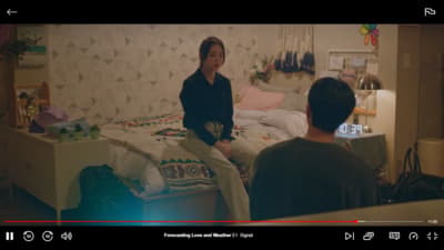 a woman sitting on a bed next to a man