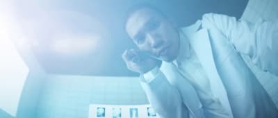 a man in a white suit talking on a cell phone