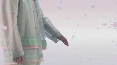 a person standing in front of a wall with confetti on it