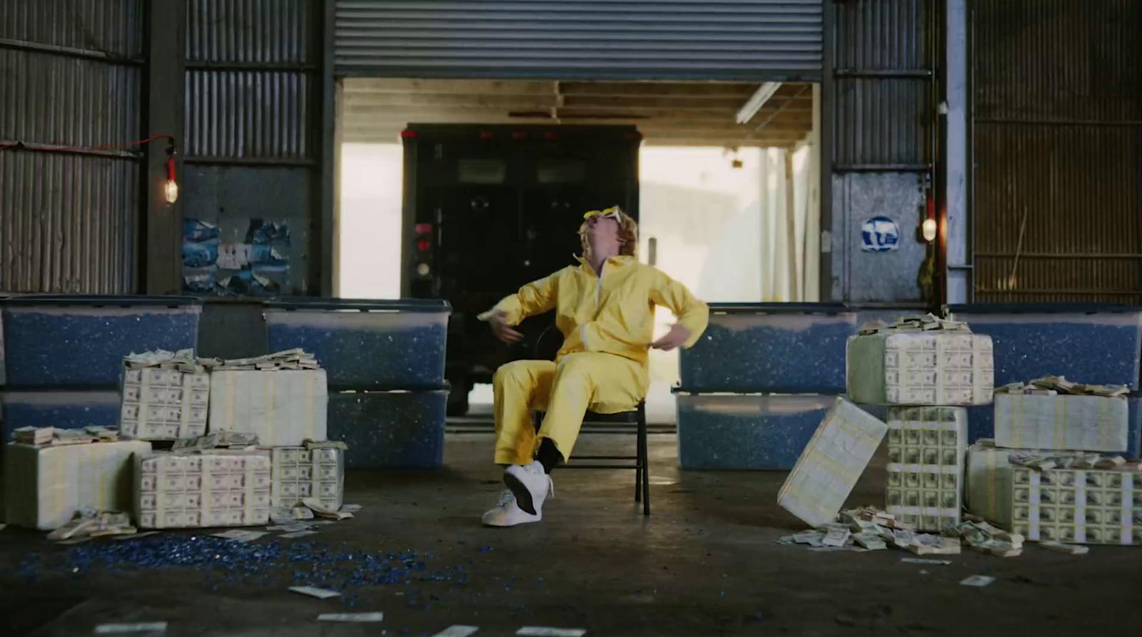 a man in a yellow suit sitting on a chair