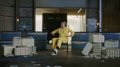 a man in a yellow suit sitting on a chair
