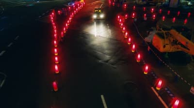 a car driving down a street with red lights on it