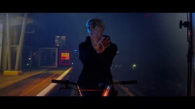a woman standing next to a bike on a street