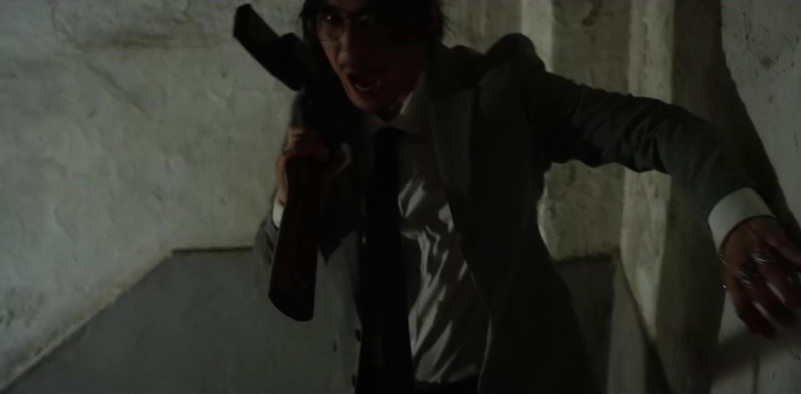 a man in a suit and tie holding a gun
