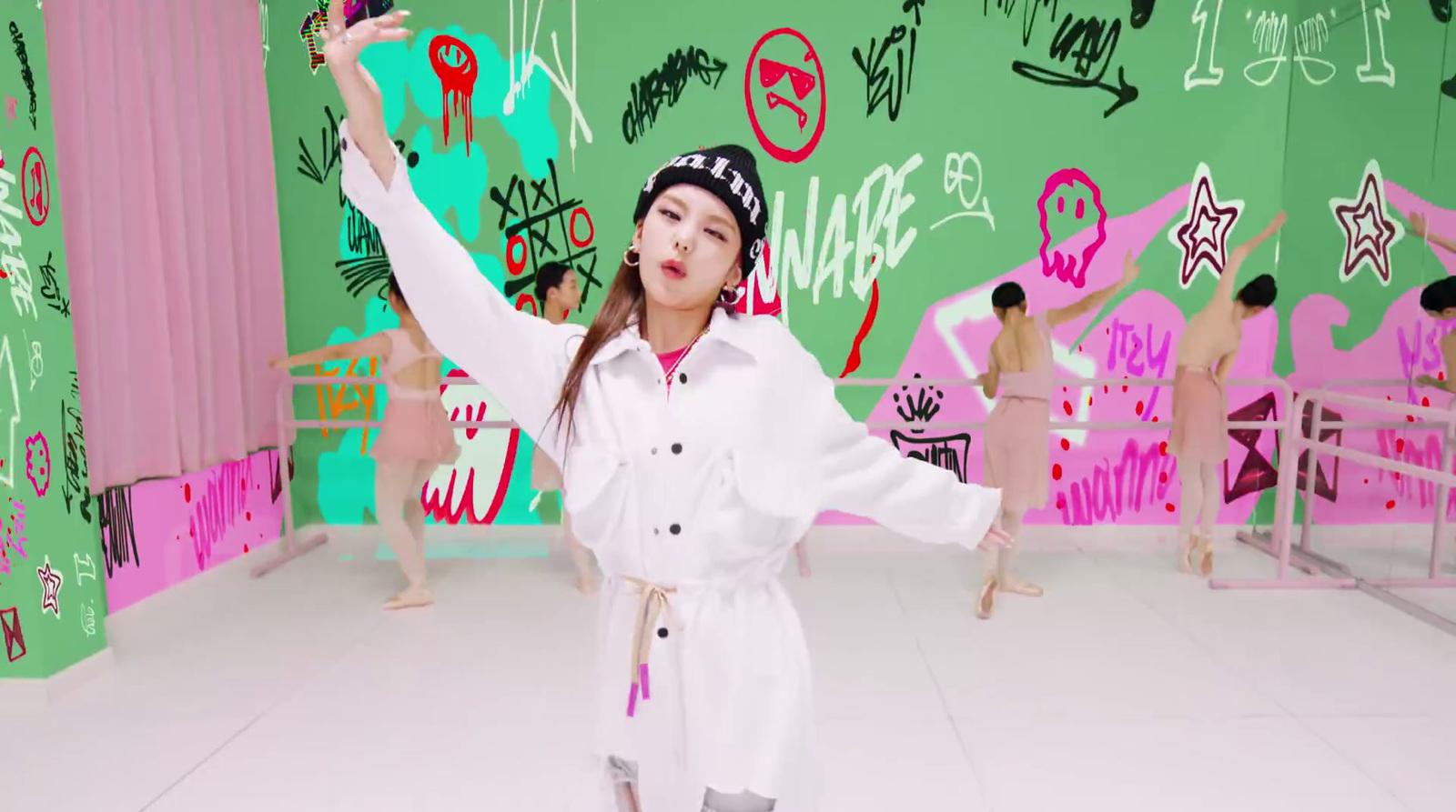 a woman in a white outfit standing in front of a colorful wall