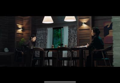 two people sitting at a table in a room