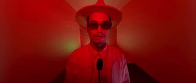 a man in a red room with a microphone