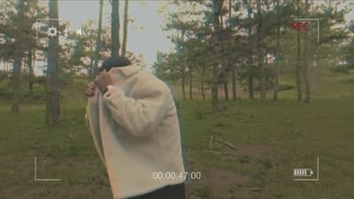 a man standing in a forest holding a camera