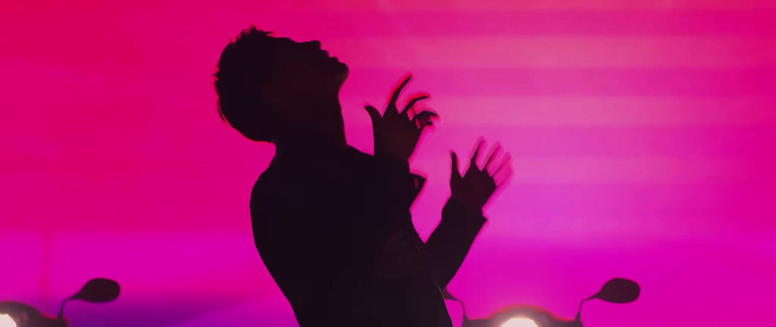 a silhouette of a person reaching up into the air