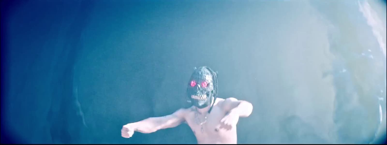a shirtless man wearing a mask and holding a tennis racquet
