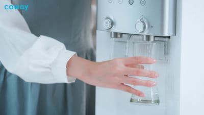 a woman is holding a glass in her hand