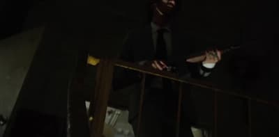a man in a suit and tie standing on a balcony
