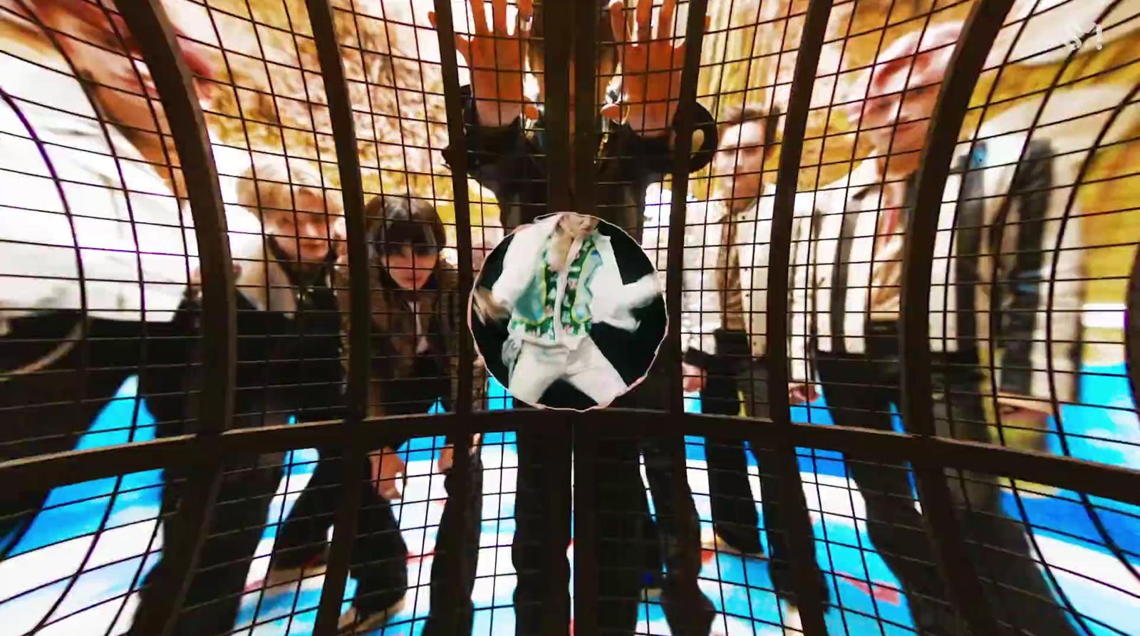 a group of people standing inside of a cage