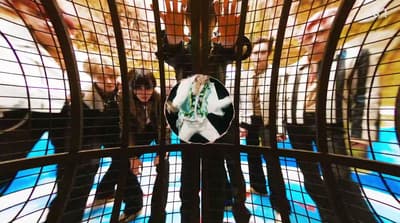 a group of people standing inside of a cage