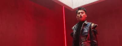a man standing in a room with a red light behind him