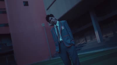 a man in a suit and tie standing in front of a building