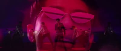 a woman with sunglasses on her face and a man in the background