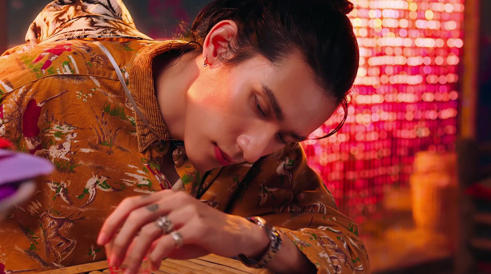 a man in a kimono looking down at a piece of wood