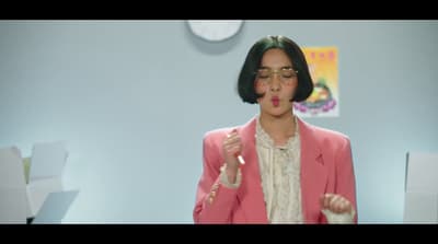 a woman wearing a pink jacket and glasses