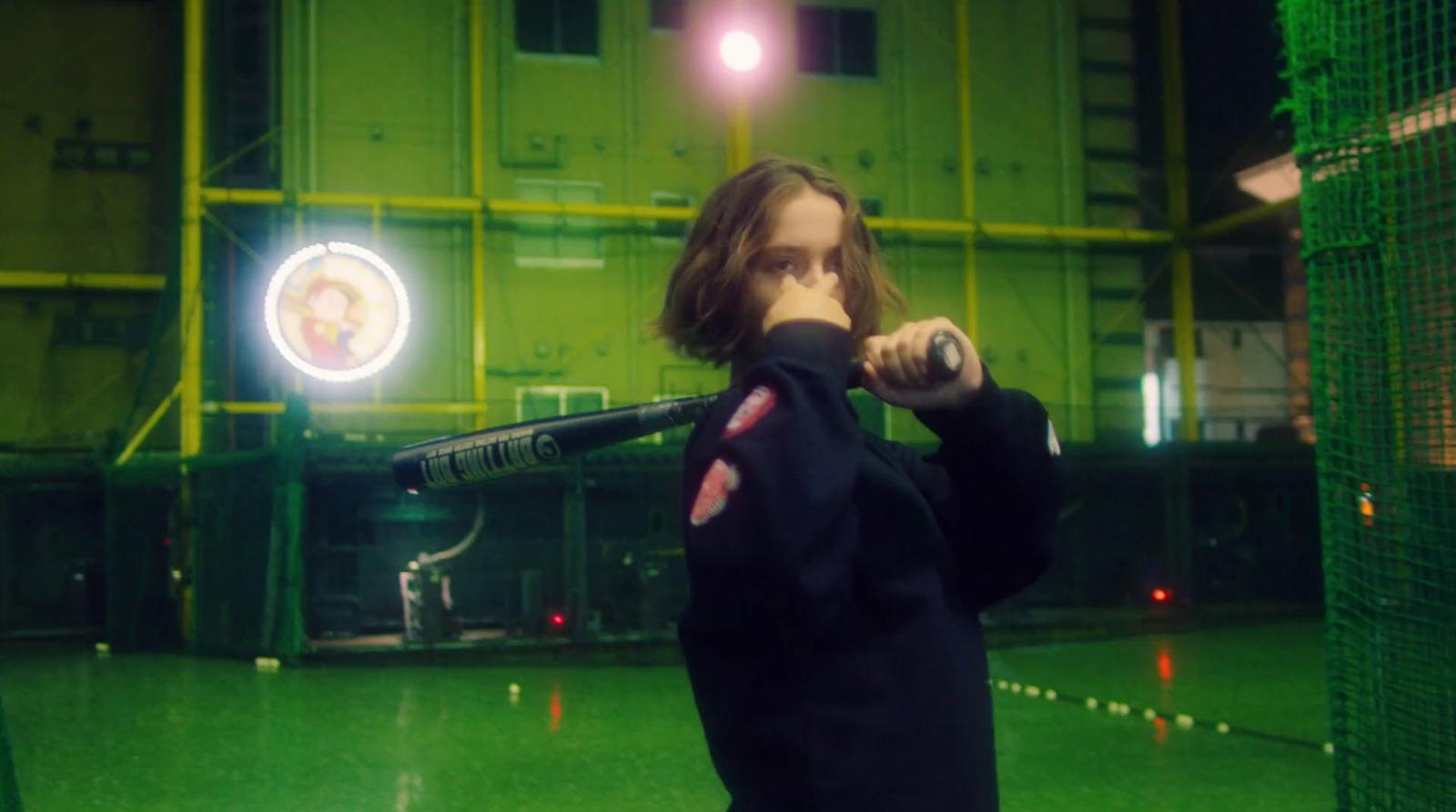 a man holding a baseball bat in a batting cage