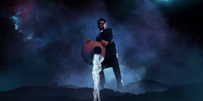 a man standing on top of a mountain holding a large object
