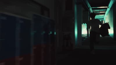 a man walking down a hallway next to a train