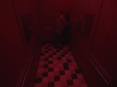 a couple of people standing in a room with a checkered floor