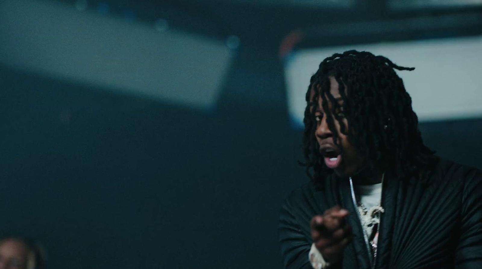 a man with dreadlocks standing in a dark room