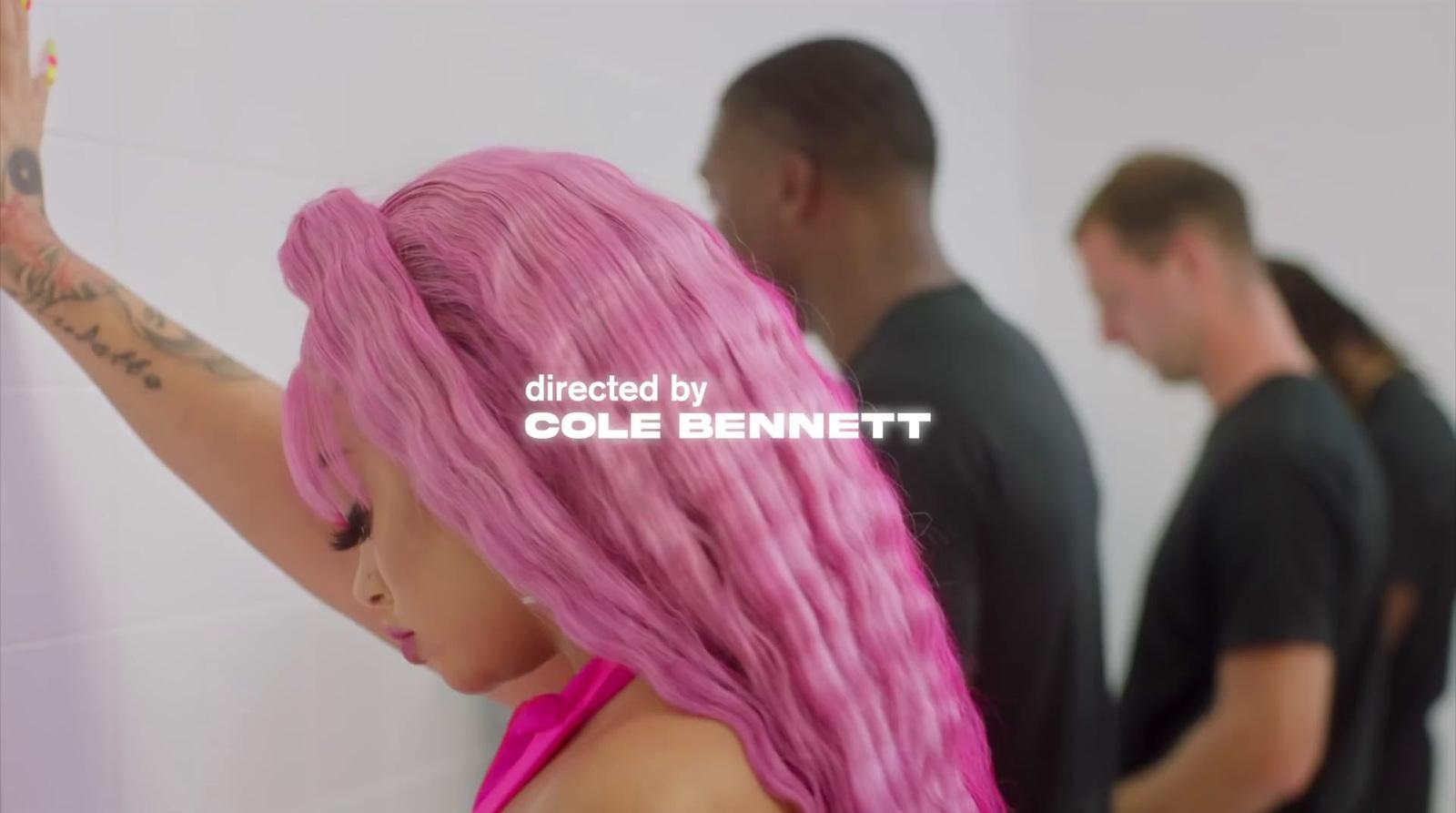 a woman with pink hair standing in front of a mirror