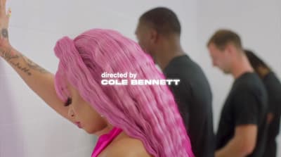 a woman with pink hair standing in front of a mirror