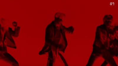 a group of people walking across a red background
