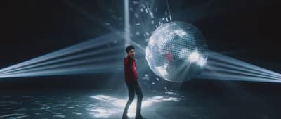 a man standing in front of a disco ball