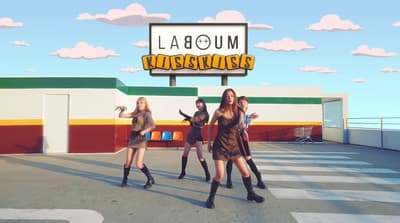 a group of young women dancing in front of a sign