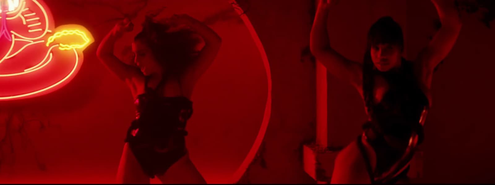 a woman standing in front of a mirror in a dark room