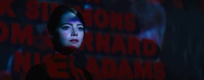 a woman standing in front of a dark background