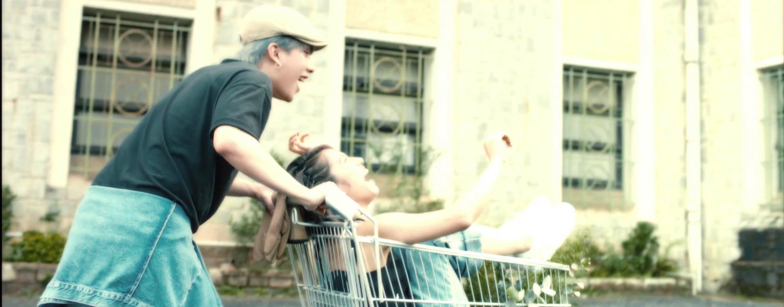 a man pushing a woman in a shopping cart