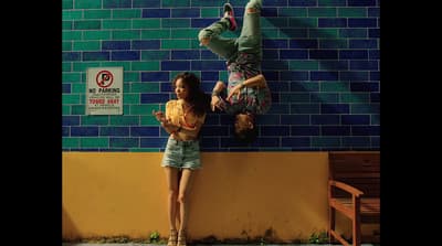 a couple of people standing next to a wall