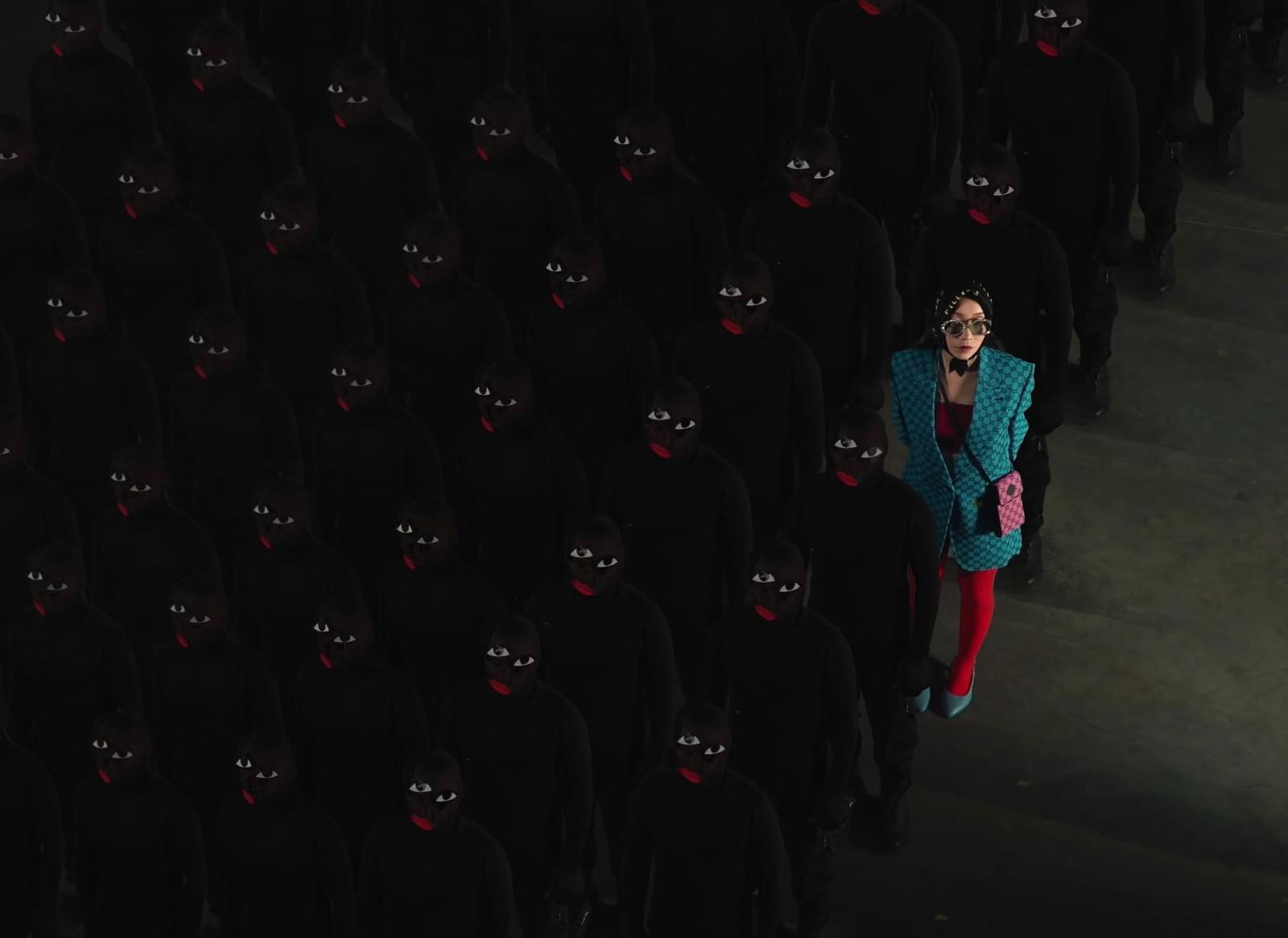 a woman standing in front of a group of black people