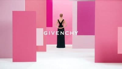 a woman standing in front of a pink and pink wall