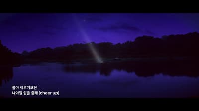 a lake with a bright light shining in the sky