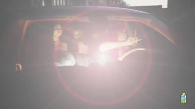 a group of people sitting in a car in the sun