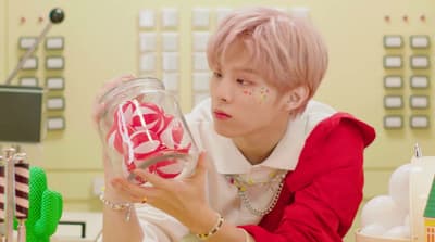 a person holding a jar with candy in it