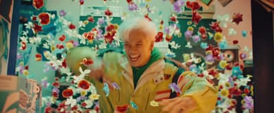 an older man standing in front of a picture of flowers
