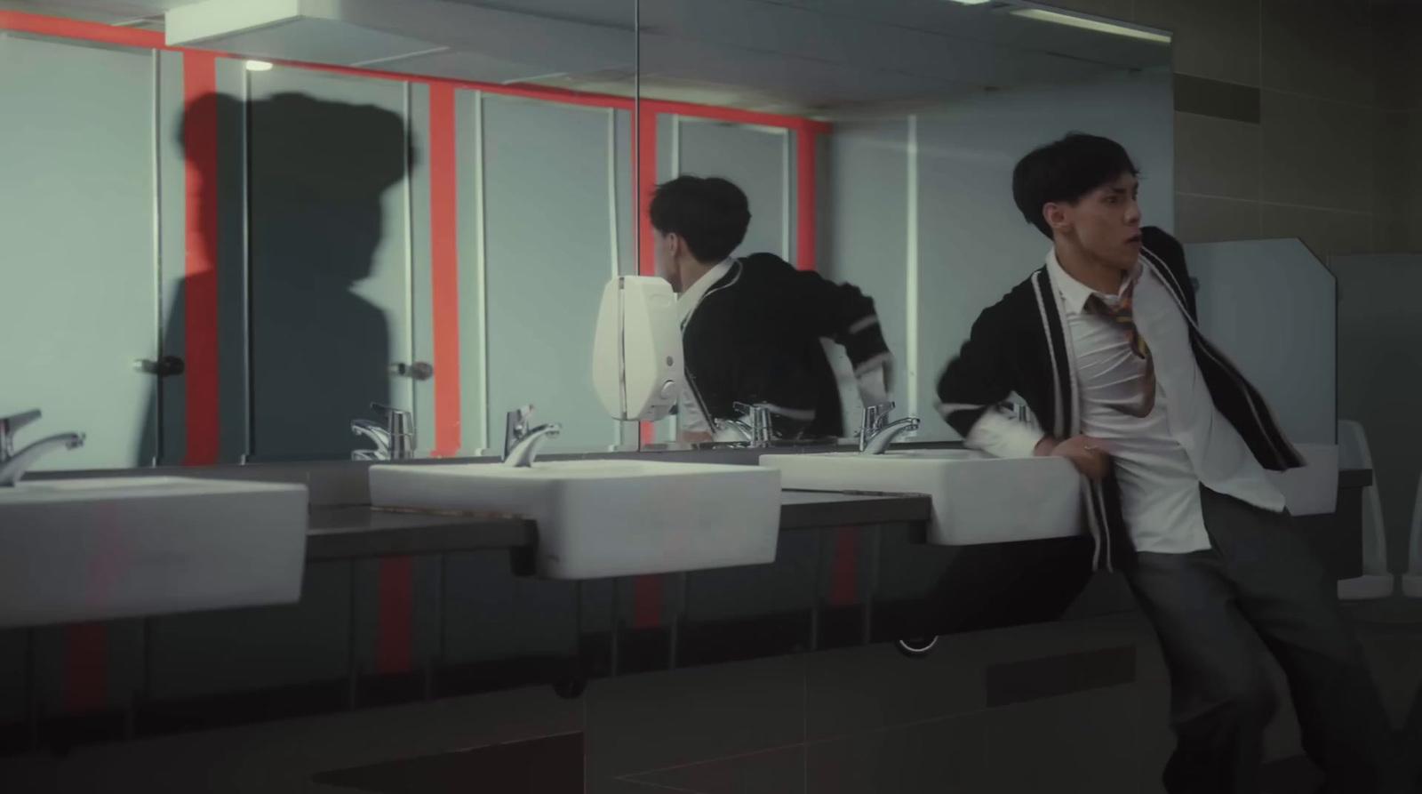 a man standing in front of a mirror in a bathroom
