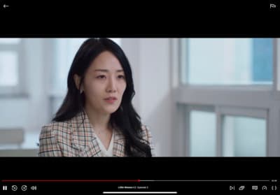 a woman with long black hair wearing a suit