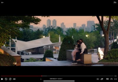 a man and woman sitting on a bench in a park