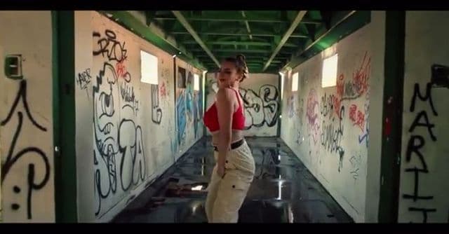 a woman standing in a hallway covered in graffiti